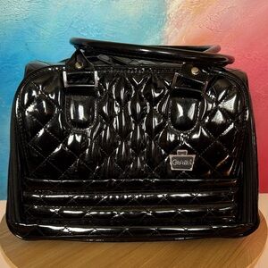 Black quilted makeup case or duffel bag by the brand CANOODLES.